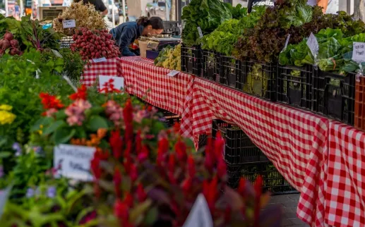 Tables filled with colorful produce at a farmer's market. 